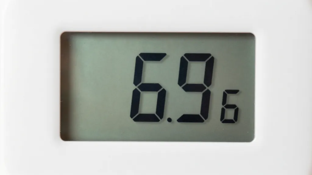How to Create a Cozy Bedroom for Better Sleep 1 Closeup of digital thermostat displaying 65 degrees Fahrenheit